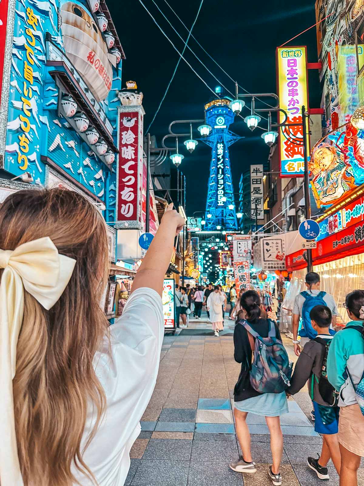 Pointing at the Tsutenkaku Tower in Shinsekai Osaka