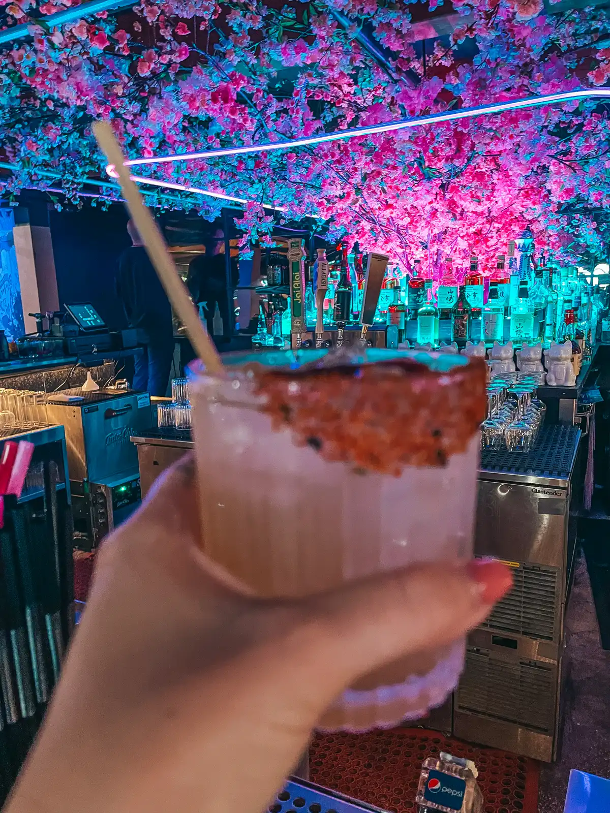 Cocktail and flower canopy above bar at Good Fortune in downtown St Pete