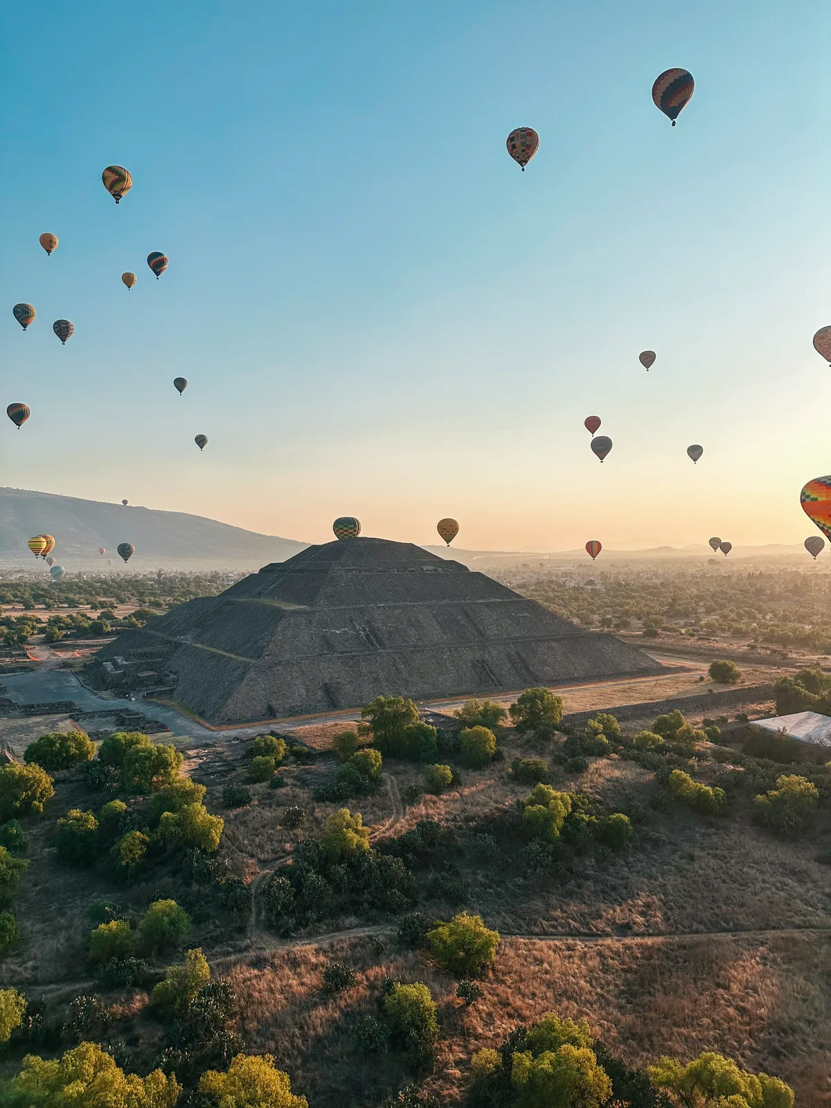 Hot air balloons floating in the sky over Teotihuacan Pyramid